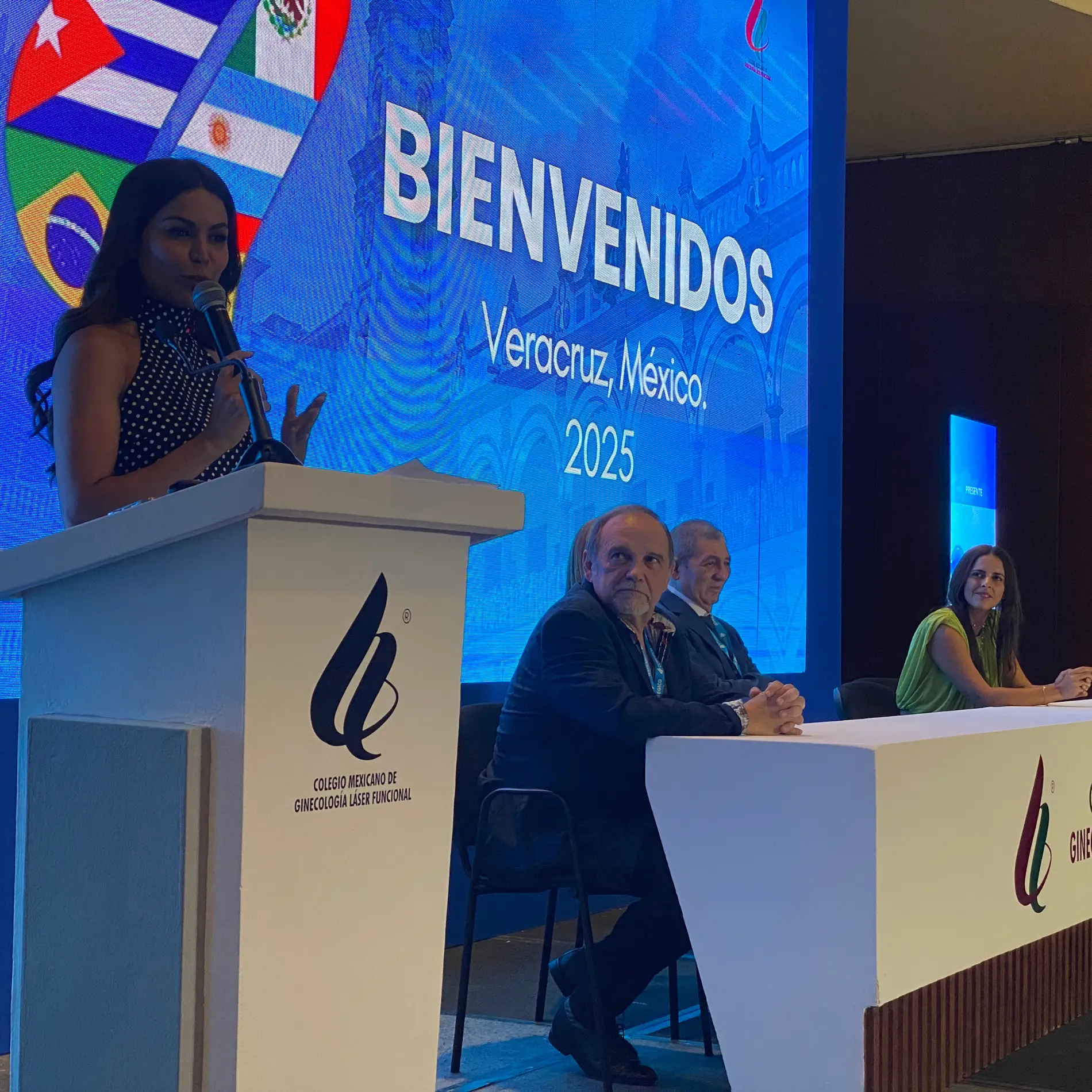Podio de bienvenida con banderas en evento internacional en Veracruz