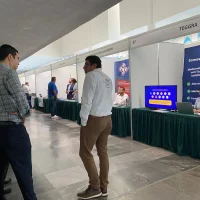 Asistentes recorriendo el piso de exposición entre stands