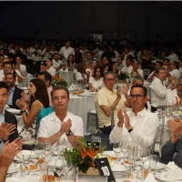 Cena de gala con asistentes sentados y aplaudiendo
